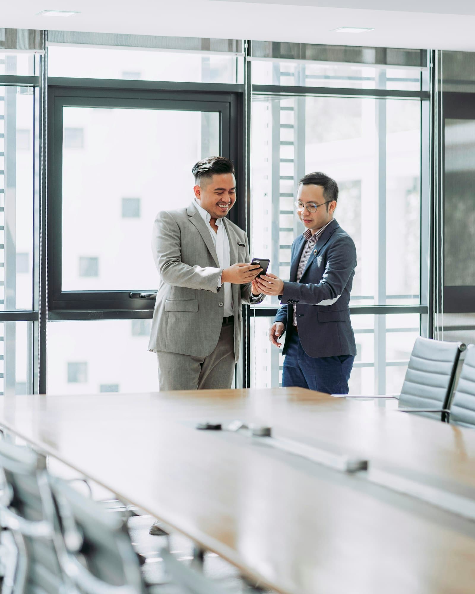 Two colleagues reviewing something in a boardroom